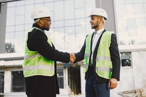 multi-racial-builders-handshaking-outdoors-wearing-uniform-talking-about-new-glass-building-working-poject-city-infrastructure (1)